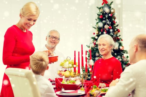 family, holidays, generation, christmas and people concept – smiling family having dinner at home