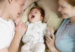 Parents in bed with newborn baby