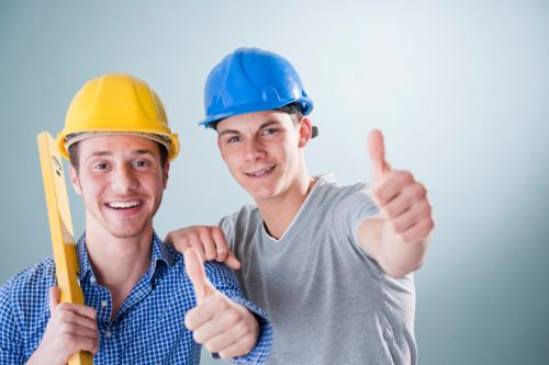 Two happy young men wearing hard hats, portrait